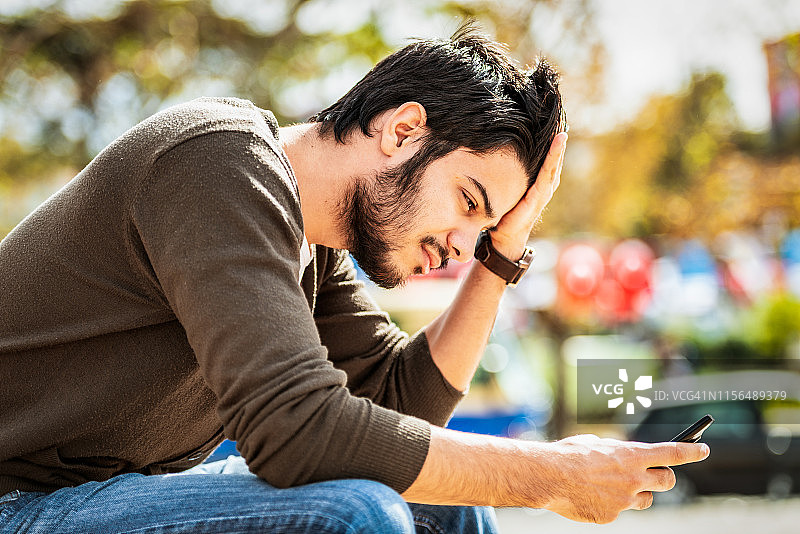 年轻男人正在阅读手机消息图片素材