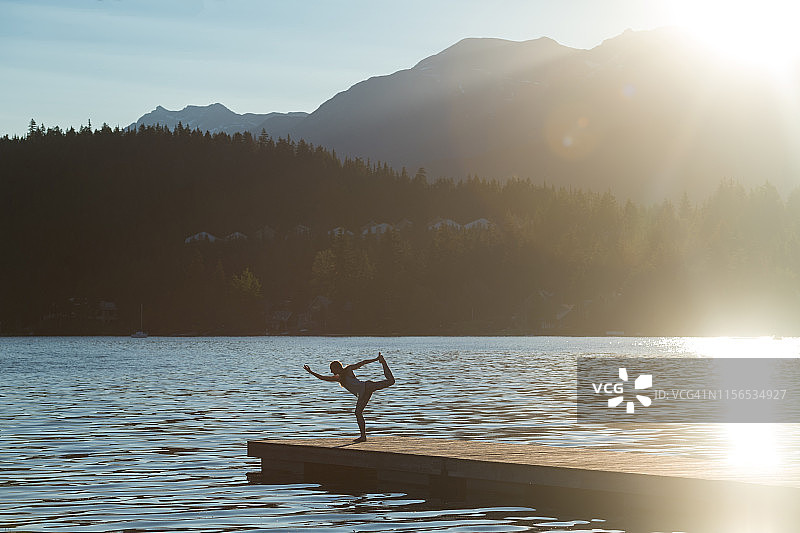 在码头上做瑜伽时伸展身体的女人图片素材