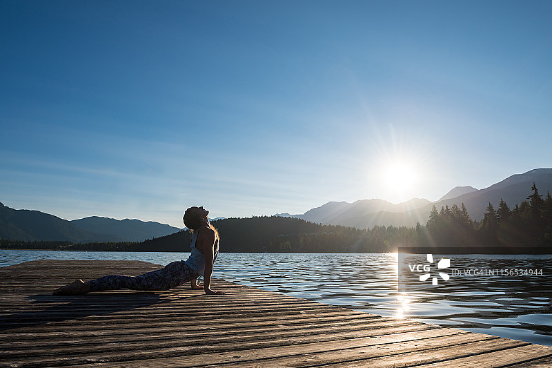在码头上做向上犬式的女人图片素材