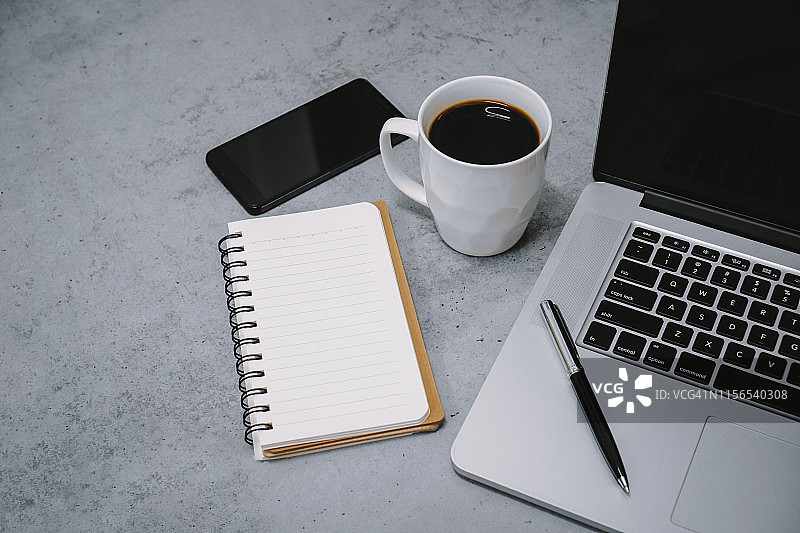 工作桌上的笔记本电脑和记事本图片素材