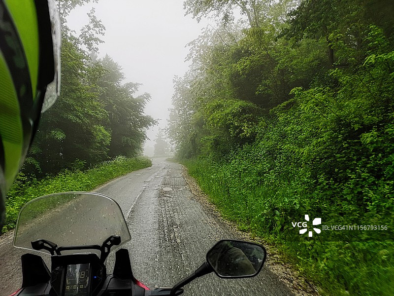 在雾中的乡村道路上骑摩托车图片素材