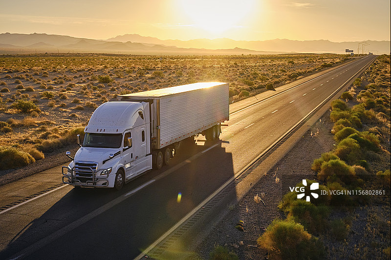 行驶在美国西部乡村州际公路上的长途半挂卡车图片素材