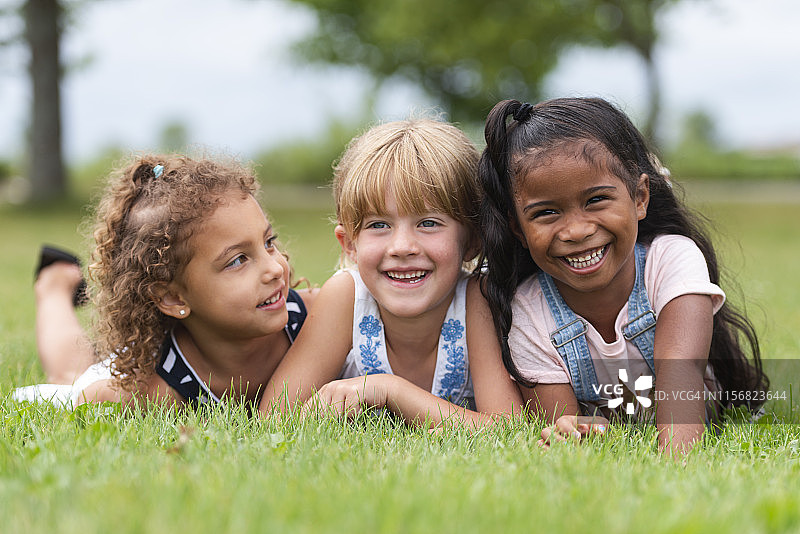 三个可爱的多种族幼儿园女孩摆姿势图片素材