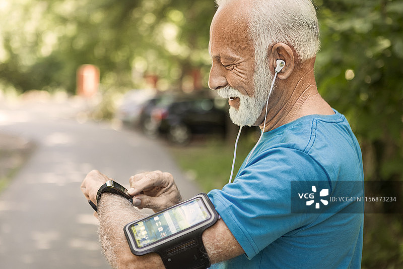 年长的男人使用智能手表测量心率图片素材