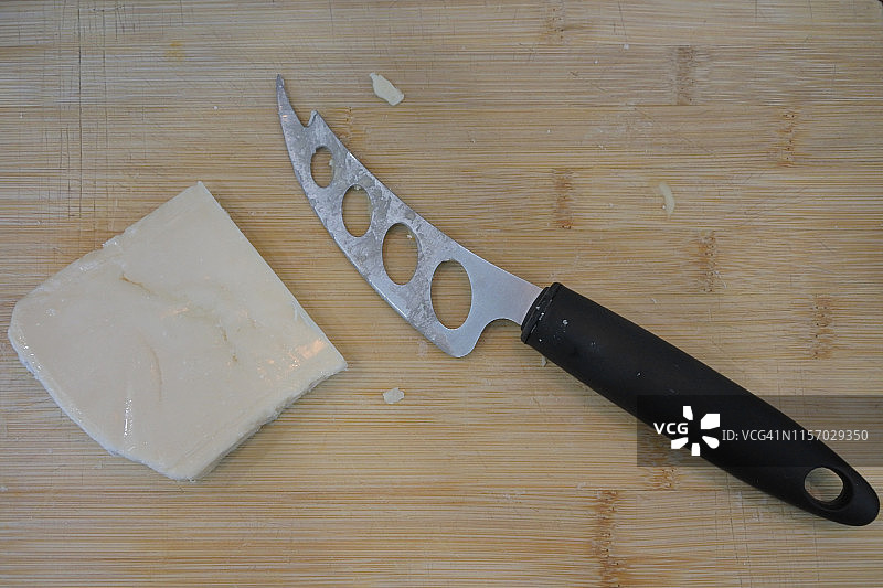 木制砧板上的奶酪刀和奶酪片图片素材
