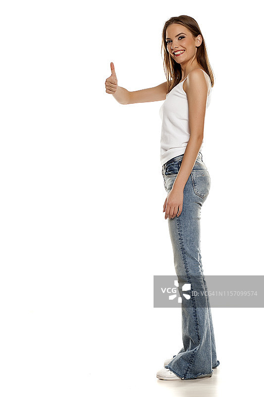 快乐的年轻漂亮女人竖起大拇指图片素材