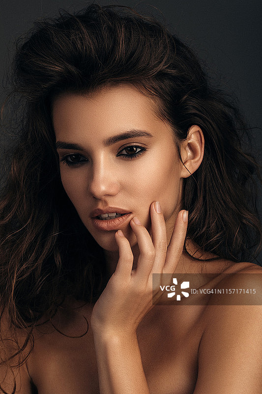有着长长的波浪卷发的年轻漂亮女模特图片素材