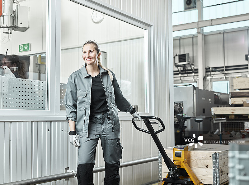 工业场景：使用托盘车的女人图片素材
