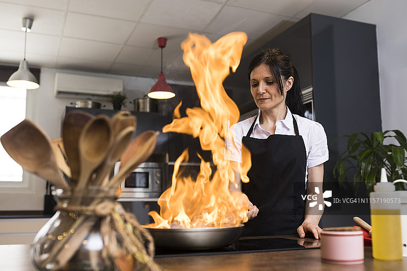 女人在厨房里用平底锅烹饪食物图片素材