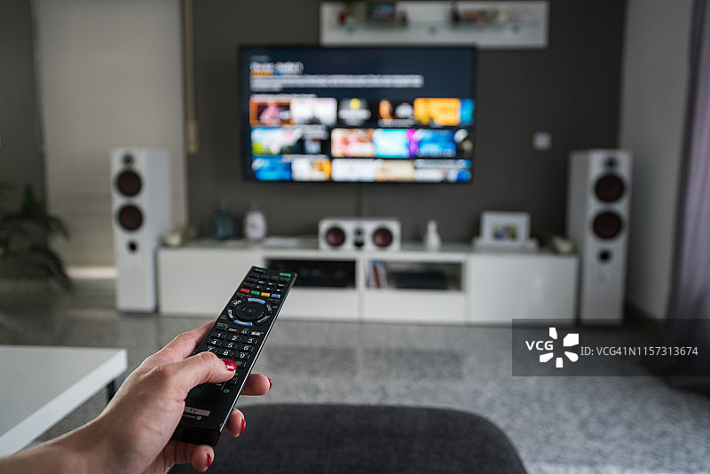 客厅里用遥控器控制电视图片素材