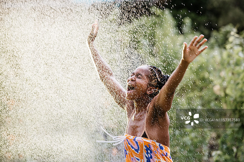 年轻女子在户外享受水雾图片素材
