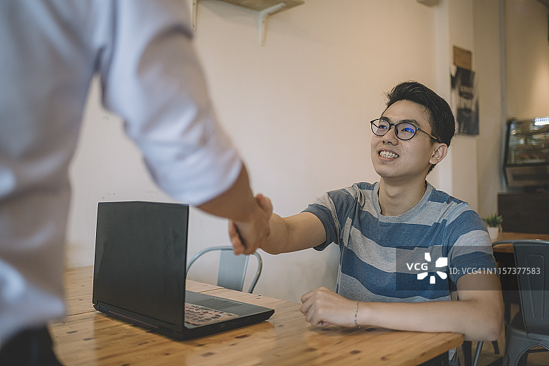 华人男子在咖啡馆与保险代理人会面图片素材