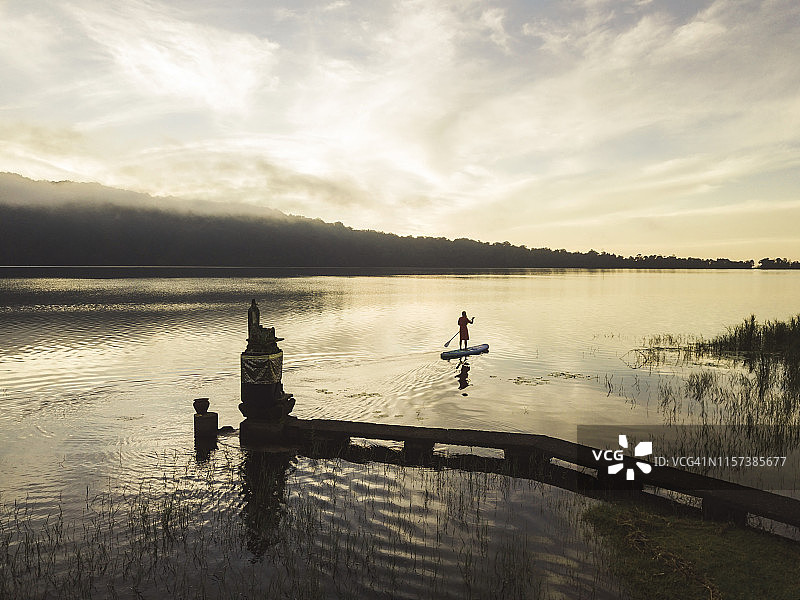 一位女子在湖上划桨板图片素材