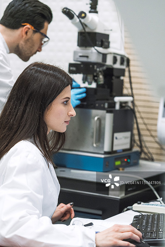 科研人员在现代化实验室使用显微镜图片素材