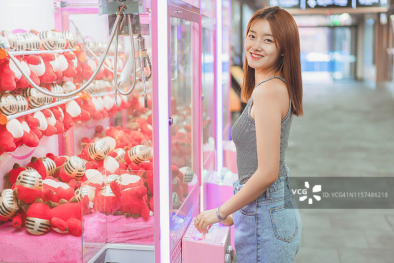 年轻女人玩街机游戏图片素材