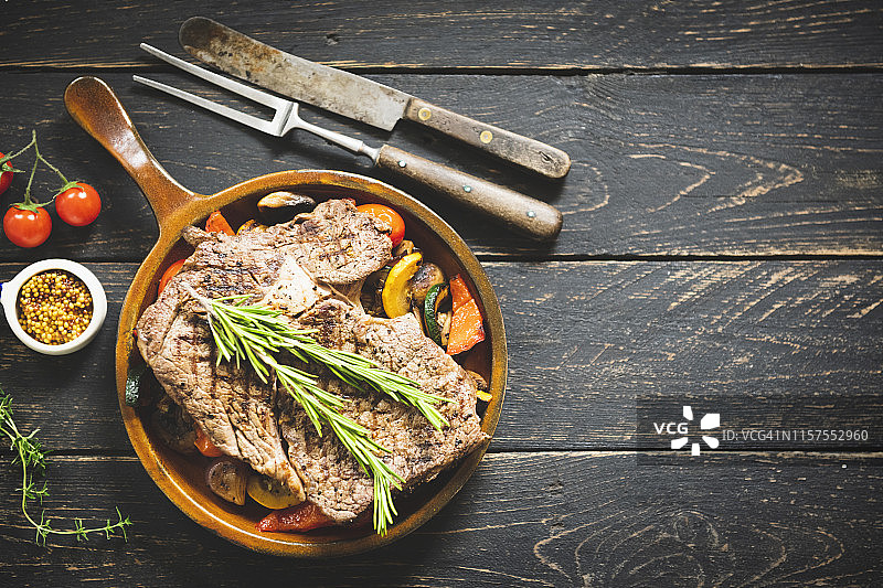 烤牛排，深色木桌背景，顶视图图片素材