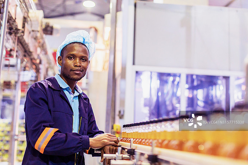 站在传送带旁的工厂工人图片素材