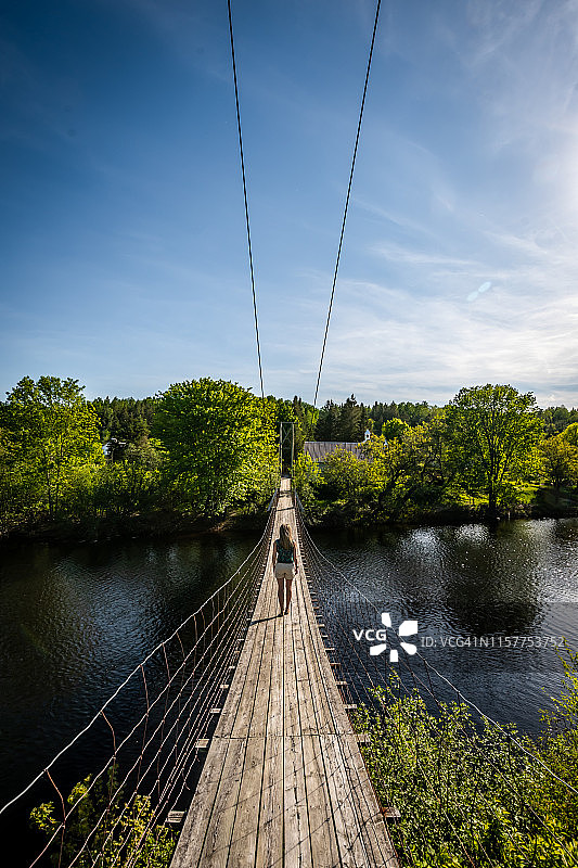 在魁北克走过悬索桥的女人图片素材
