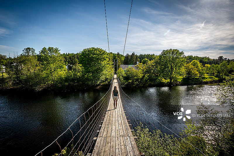 在魁北克走过悬索桥的女人图片素材