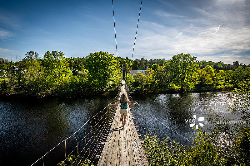 在魁北克走过悬索桥的女人图片素材