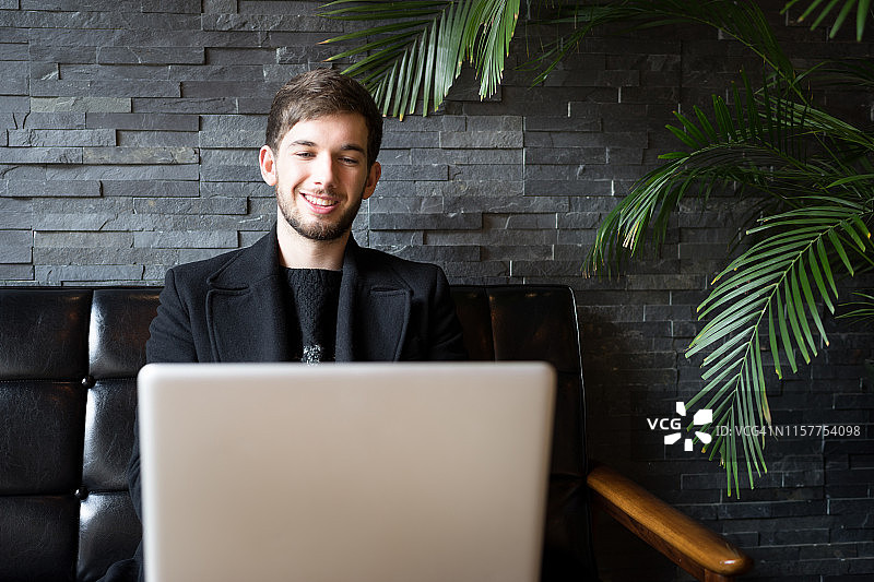 男人在咖啡店用笔记本电脑工作图片素材