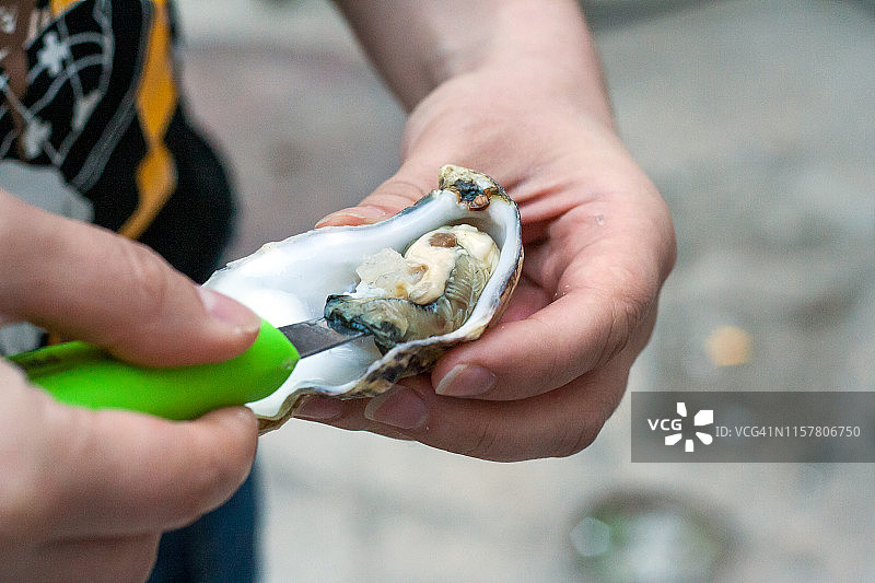 一位不知名人士正在准备新鲜的牡蛎图片素材