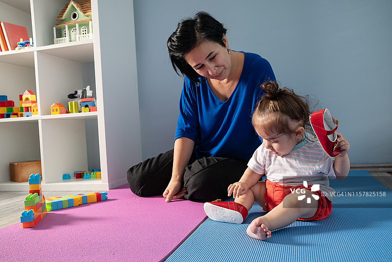 女婴拿着鞋子准备迈出第一步图片素材