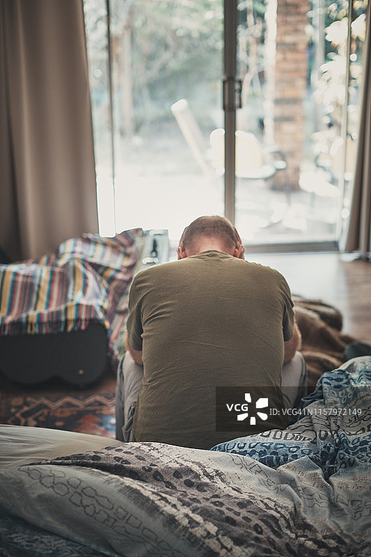 早上卧室里疲惫和绝望的中年男子图片素材