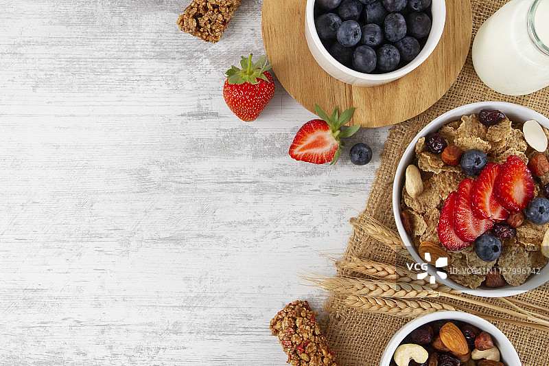 白木桌上的坚果浆果玉米片图片素材