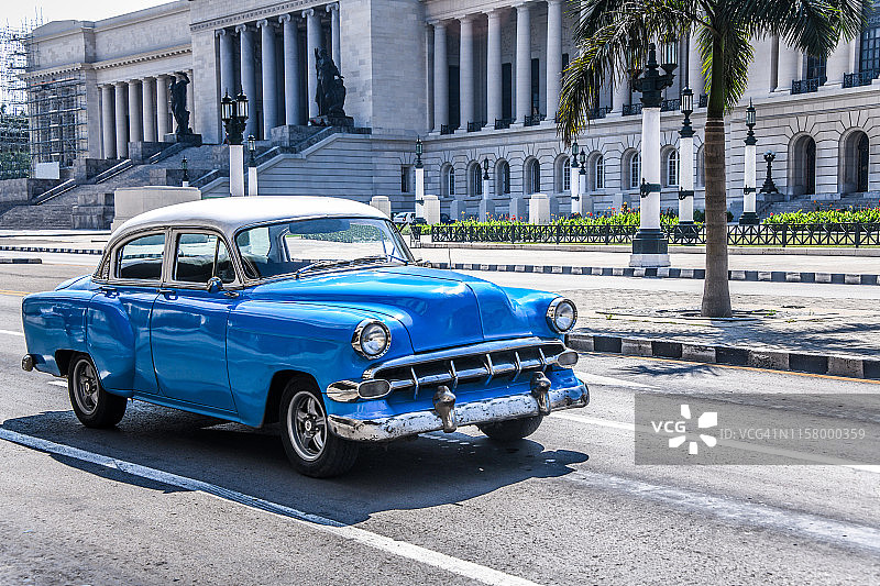 古巴哈瓦那国会大厦附近的蓝色老爷车图片素材