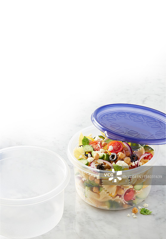 带蓝色盖子的食品盒中的意大利面沙拉图片素材