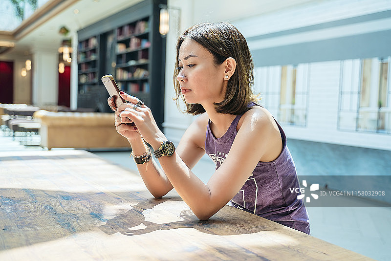 在豪华酒店大堂区域使用手机的女人图片素材