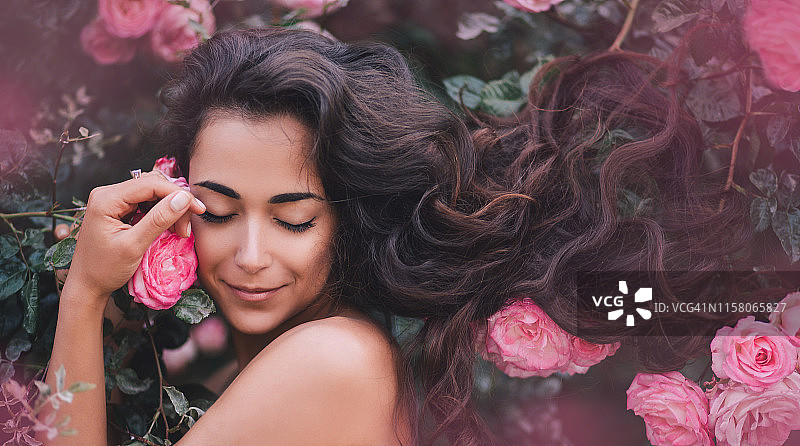 手持玫瑰的长卷发女人图片素材