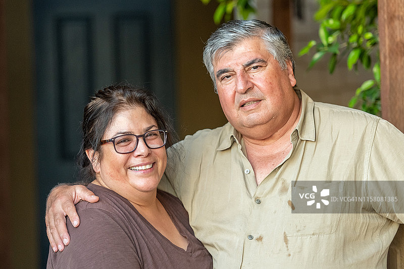 微笑的成熟老年夫妇看着镜头摆姿势图片素材