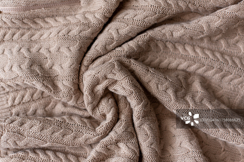 美利奴羊毛手工针织大毛毯，超粗纱线，潮流概念。针织毛毯特写，美利奴羊毛背景。米色烟熏羊毛制成的设计师毛毯。图片素材