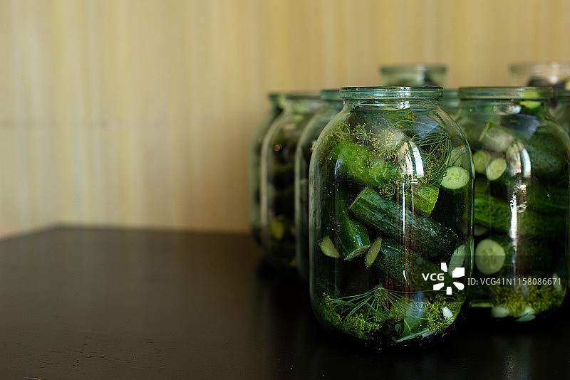 厨房餐桌上的大小玻璃罐装自制腌黄瓜图片素材