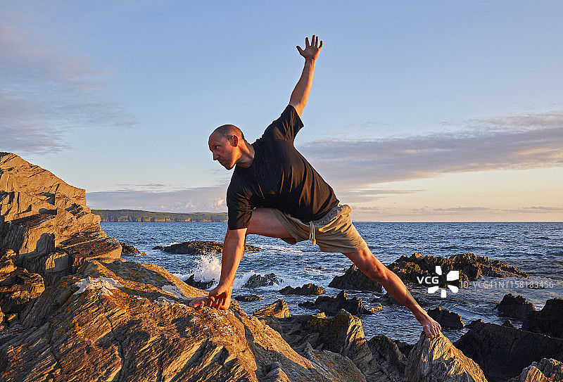 男子在英国德文郡练习展臂侧伸展式瑜伽图片素材