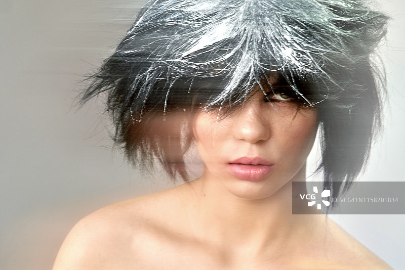 一位画着几何眼线、态度酷酷的年轻女人图片素材