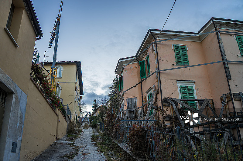清晨在拉奎拉的受损建筑物和起重机图片素材