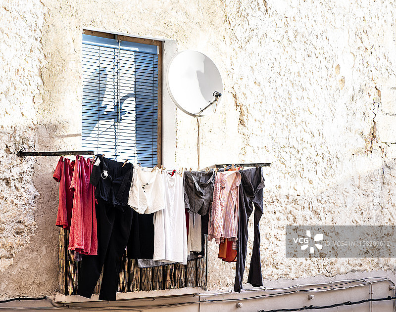 乡村村庄的阳台，晾晒着衣服和一个抛物面天线图片素材