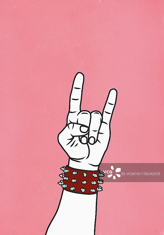 手戴铆钉袖口，做出摇滚手势图片素材