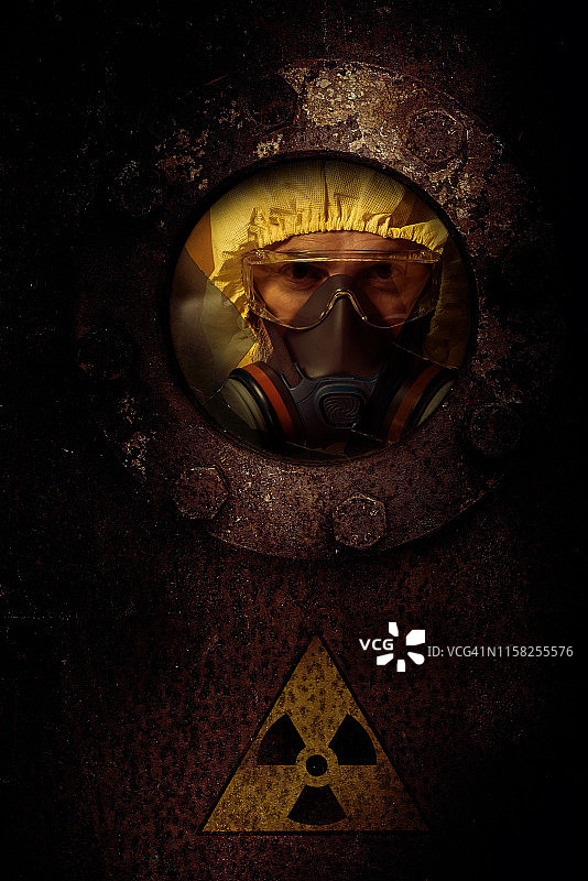 戴防护眼镜的工人正在检查金属门上的孔洞图片素材