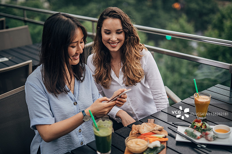 为美食博客拍照的年轻女性图片素材