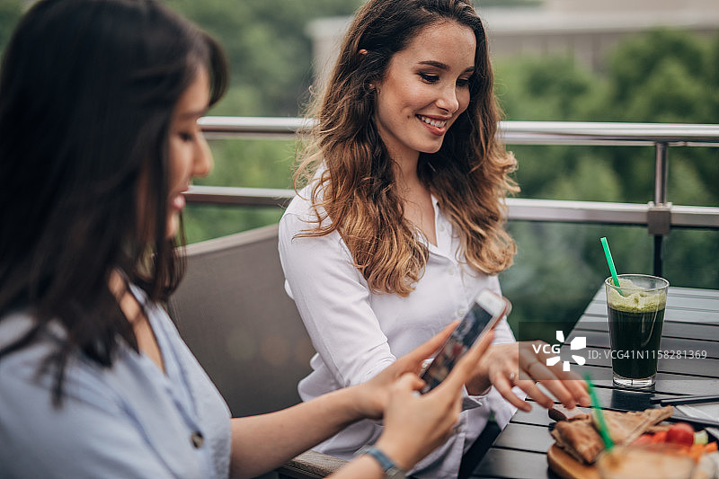 为美食博客拍照的年轻女性图片素材