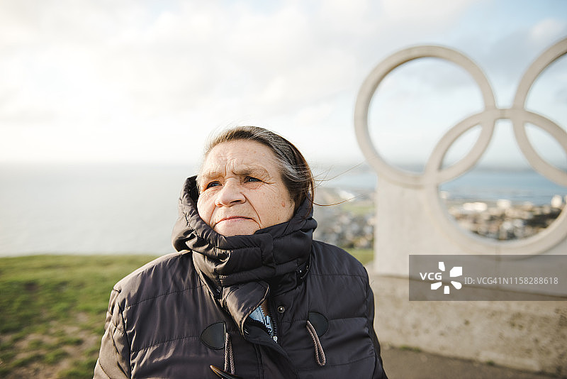 年长的女人在海边旅行，冷风吹拂图片素材