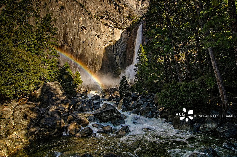 冉冉升起的太阳照亮了优胜美地瀑布的底部，形成一道彩虹图片素材