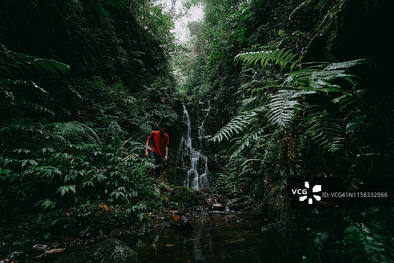 日本东京八丈岛丛林瀑布边的男人图片素材
