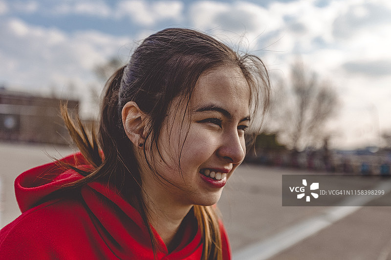 在城市风景中站在外面的微笑混血女人图片素材