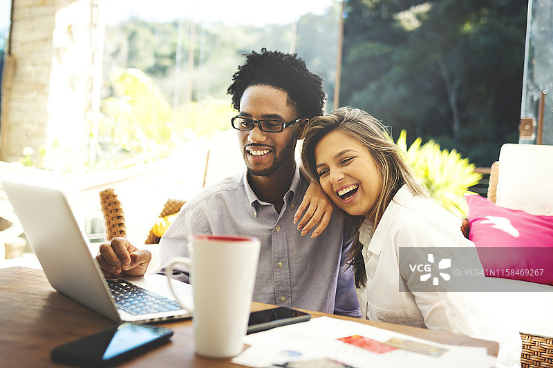 情侣坐在客厅里使用笔记本电脑、信用卡和手机图片素材