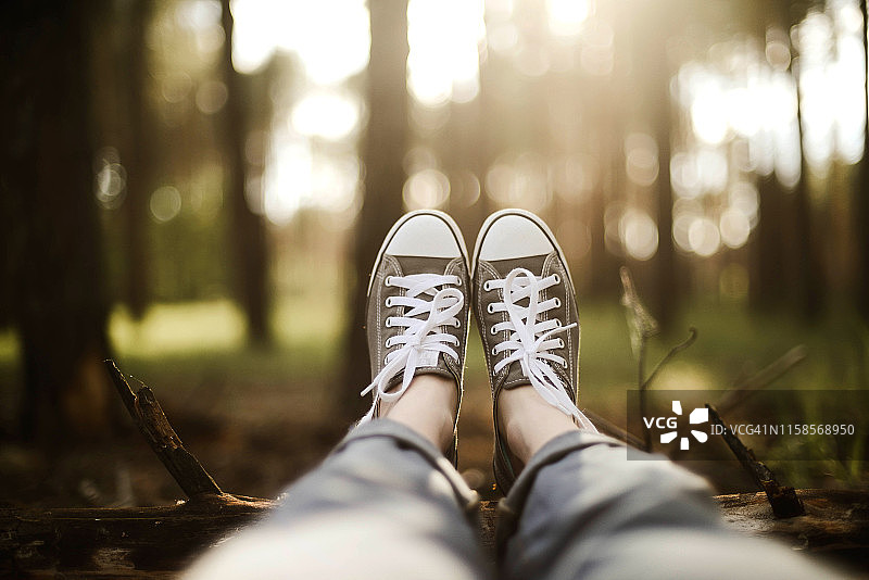 女子坐在森林田野上的下半身视角图片素材